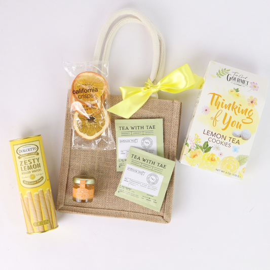 Seattle Thinking of You gift basket in jute tote with lemon tea cookies, tea sachets, honey, dried orange slices, and yellow bow