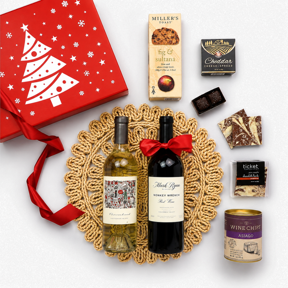 A curated gift hamper featuring a red Christmas-themed box with a white tree, a bottle of white wine, a bottle of red wine tied with a red ribbon, assorted chocolates, and a can of wine chiff, all arranged on a white background.